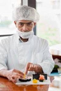 Koch mit Mundschutz beim Zubereiten