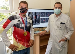 Prof. Alexander Disch, Leiter des Universitäts-Wirbelsäulenzentrums und Koordinator Sportmedizin am OUPC, und Tom Liebscher vor den CT-Aufnahmen der gebrochenen Wirbelfortsätze.  Marc Eisele  Universitätsklinikum Carl Gustav Carus Dresden